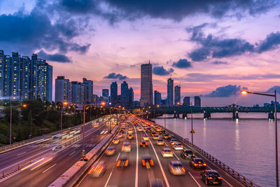 Panoramic view of illuminated city against sky during sunset