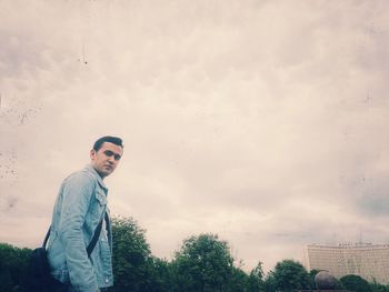 Young man standing against sky