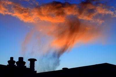 Low angle view of smoke emitting from chimney against sky