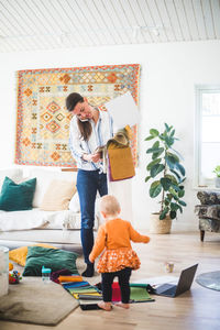 Rear view of mother with daughter standing at home