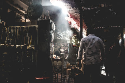 Rear view of woman standing at market stall