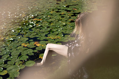 Midsection of woman with leaves in water