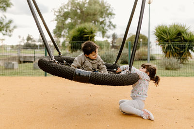 Rear view of woman sitting on swing at playground