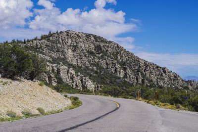 Road by mountain against sky