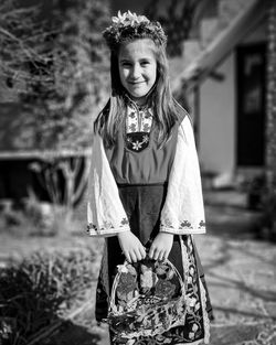 Portrait of smiling young woman standing by plants