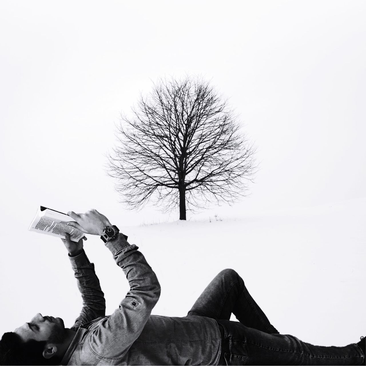 MAN PHOTOGRAPHING WITH UMBRELLA ON TREE AGAINST SKY