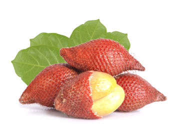 Close-up of strawberries on plate against white background