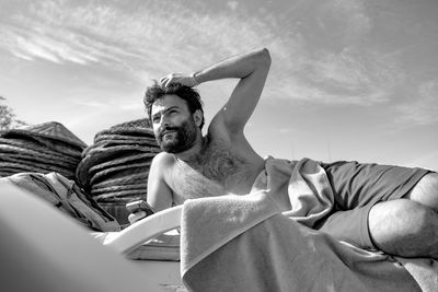 Portrait of young man sitting against sky in cyprus