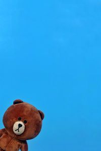 Low angle view of stuffed toy against blue sky