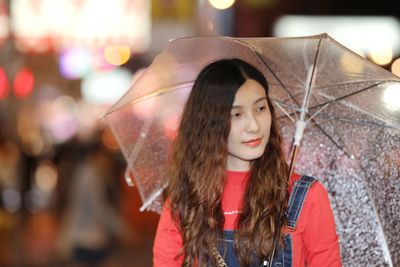 Portrait of woman with umbrella in rain