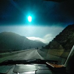 Road seen through car windshield at night