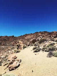 Scenic view of desert against clear blue sky