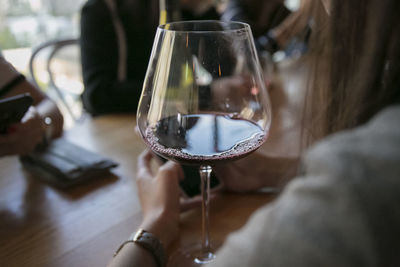 Close-up of woman holding glass of wine