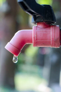 Close-up of hand holding red umbrella