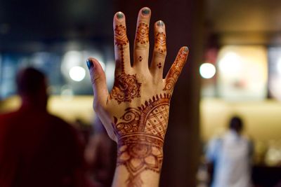 Close-up of woman showing hand with henna tattoo
