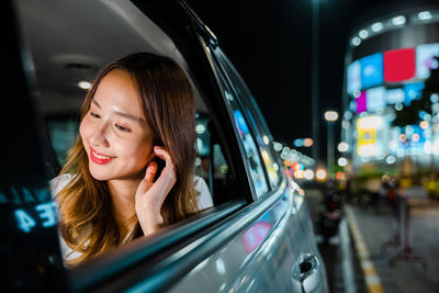 Reflection of woman reflecting on side-view mirror of car