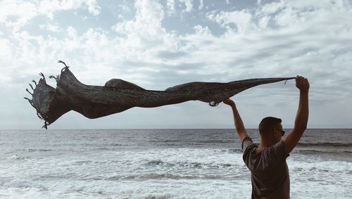 Man standing on beach against sky