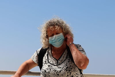 Portrait of woman against blue sky