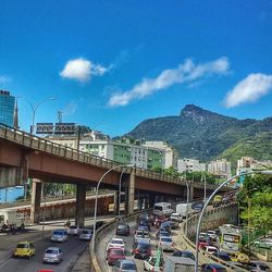 Cars on road against cloudy sky