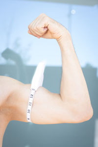 Man measuring bicep with caliper