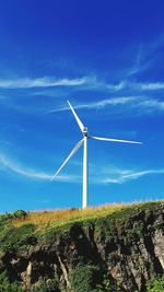 Wind turbines on field against sky