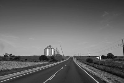 View of road passing through land against sky