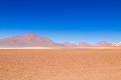 Scenic view of desert against blue sky