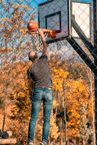 Rear view of man playing basketball