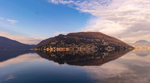 Scenic view of lake by mountains against sky