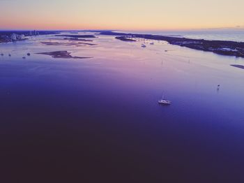 High angle view of sailboats at sea against sky during sunset