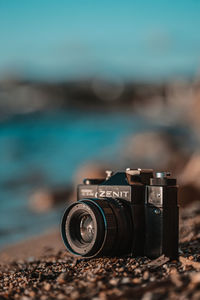 Close-up of camera on beach against sky