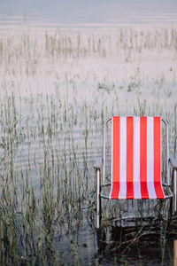 Red flag on field by lake