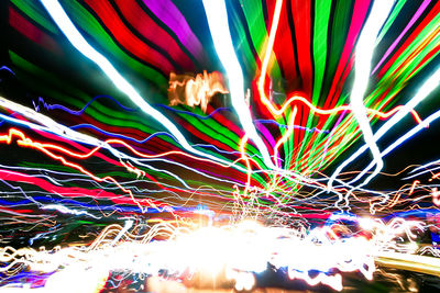 Low angle view of light trails against sky at night