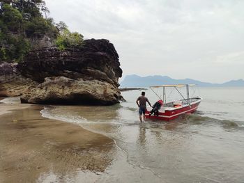 Man in boat on sea against sky