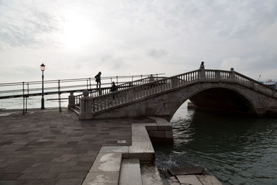 Footbridge over water against sky