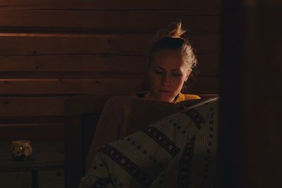 Young woman reading book at home