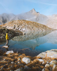 Man standing on rock by lake