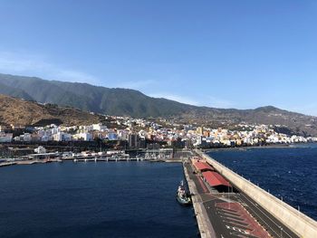 Scenic view of sea and buildings against clear blue sky