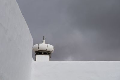 Low angle view of snow covered building against sky