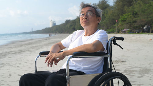 Mid adult man sitting on skateboard