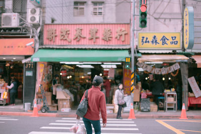 Rear view of man walking on city street