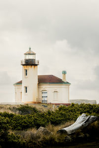 Lighthouse by sea against sky