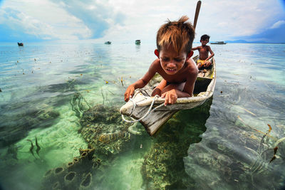 Portrait of boy in sea against sky