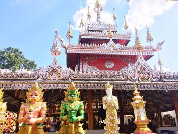 Low angle view of statues on building against sky