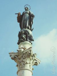 Statue in city against clear sky