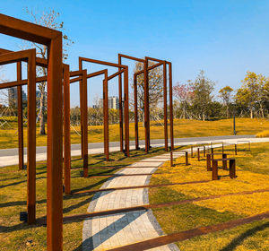 Footpath in park against clear blue sky