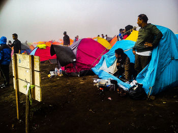 Group of people sitting in traditional clothing against sky