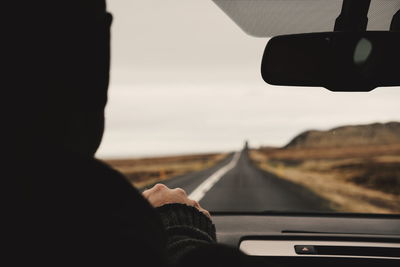 Close-up of man driving car on road