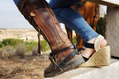 Low section of person wearing leather shoes