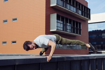Athletic man doing parkour exercises outdoors person